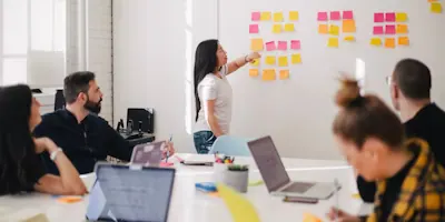 A team mapping ideas across a wall of sticky notes during a workshop session