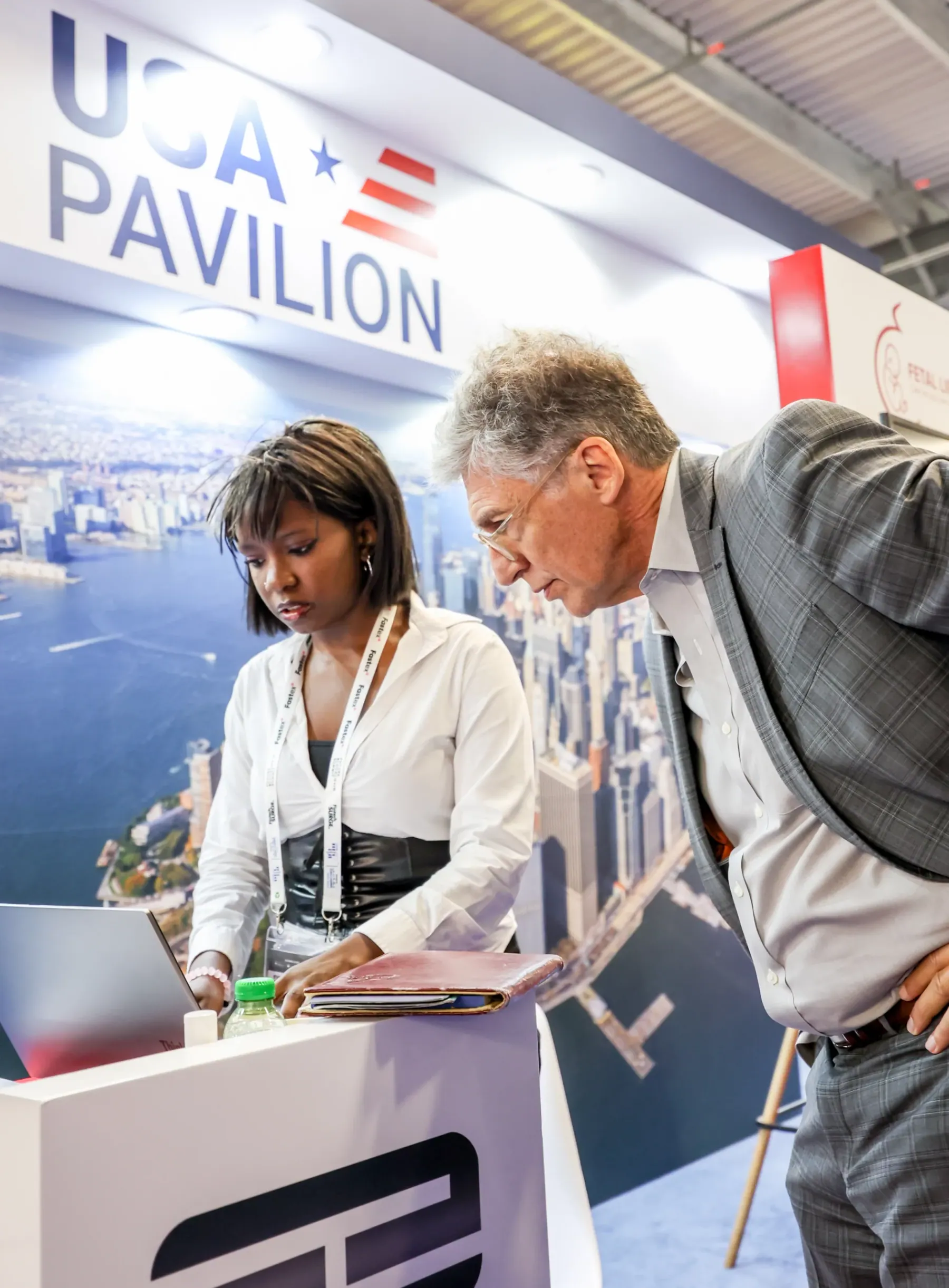 Two visitors reviewing a demo at the USA Pavilion stand